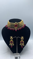 Choker style gold plated Kundan set with ruby coloured moti adorned with ruby colour stone and comes with matching earrings