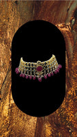 Choker style gold plated Kundan set with ruby coloured moti adorned with ruby colour stone and comes with matching earrings